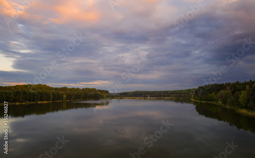 Evening sunset landscape with lake, spring and forest in Vereshchytsia, Lviv district. May 2020. Aerial drone view.