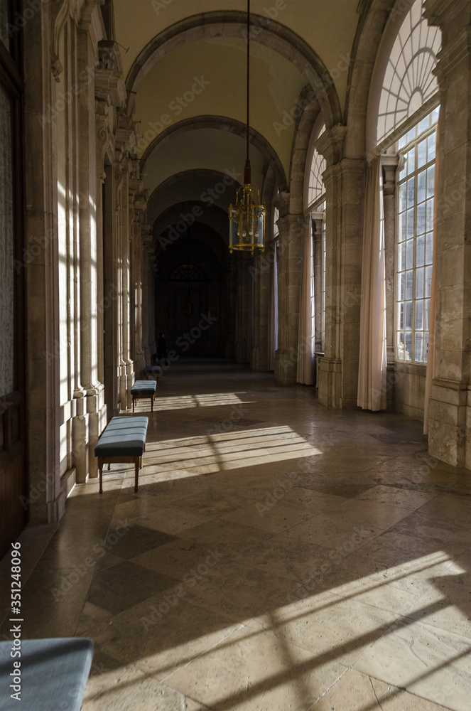 Empty hallway of a historic building while sunlight inside through the windows