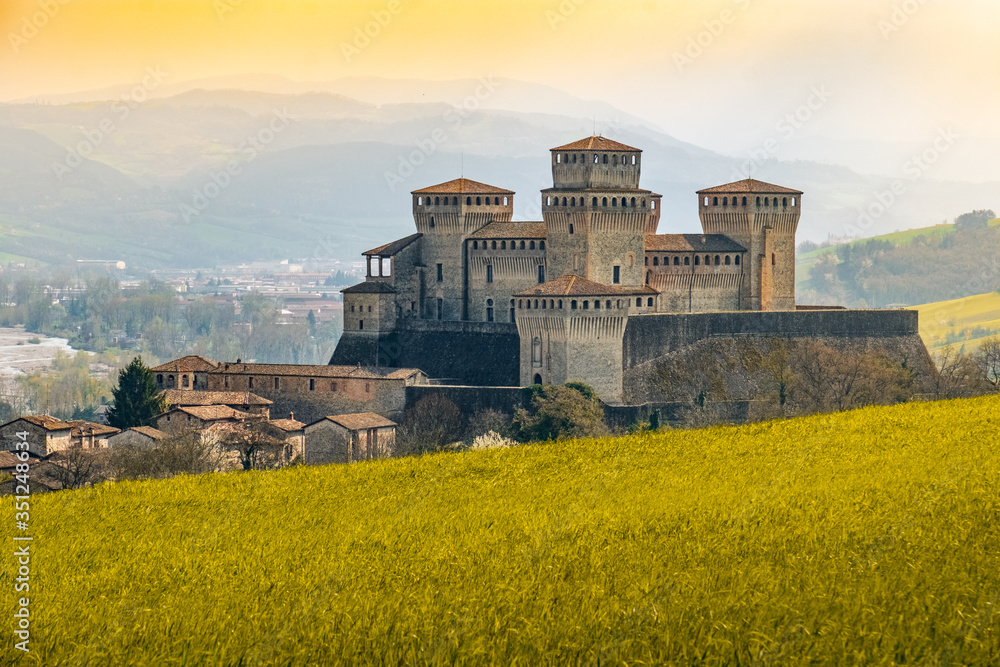 landmarks of italy, the Torrechiara fantasy castle near Parma - Italy with yellow warm toned grass and sky vintage look with copy space