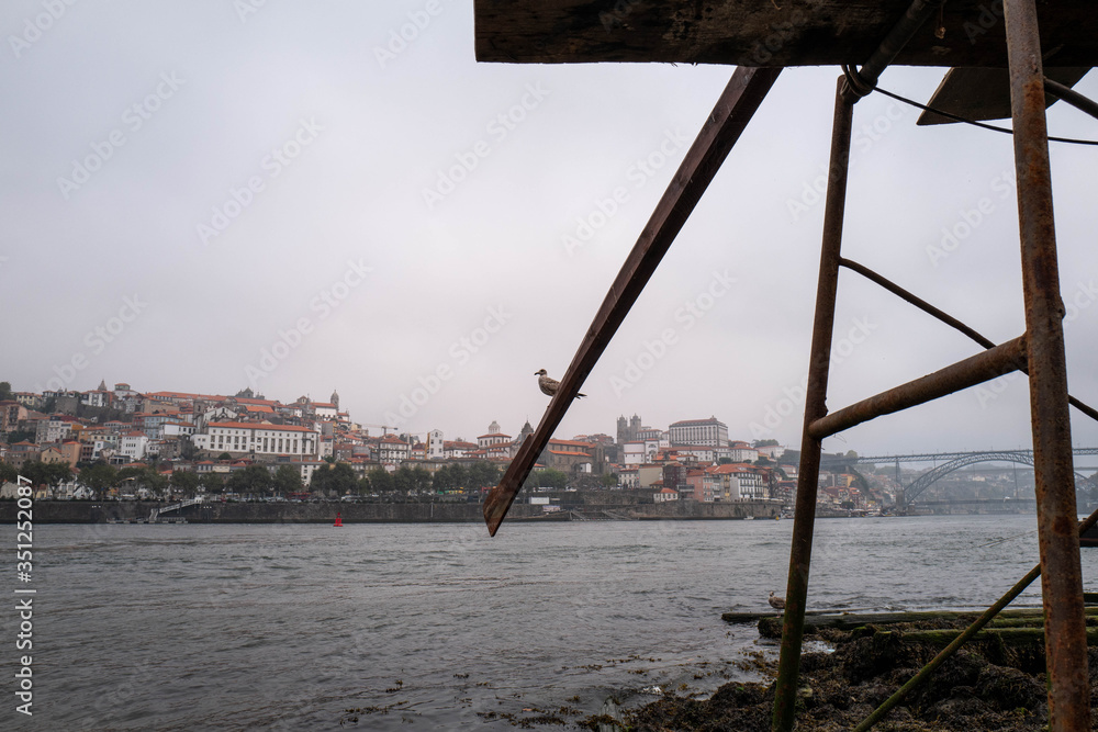 Seagulls perched on a boat mast above the Douro with the Dom-Luis bridge in the background in Porto. Seagulls perched on a boat mast above the Douro with the Dom-Luis bridge in the background in Porto.