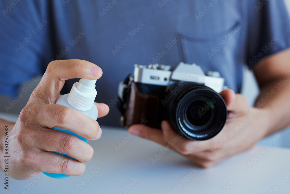 Fototapeta premium man disinfecting his camera