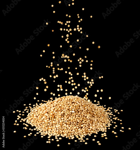 Falling quinoa seeds isolated on black background