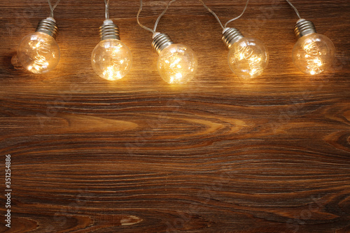 Light bulb lamps with warm light over old wooden background