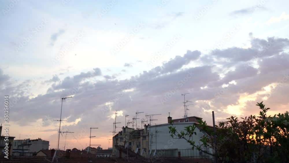 Sunset view rooftops city. Stunning colors in the sky. Clouds shape and orange lights. Romantic and relaxing balcony view Sunset view rooftops city. Stunning colors in the sky. Clouds shape and orange lights. Romantic and relaxing balcony view