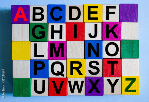 The letters of the alphabet are written on multi-colored cubes on a blue background.