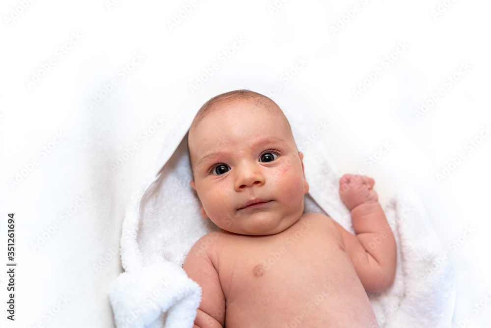 Adorable 2 months old little baby boy on towel after bath over white background Adorable 2 months old little baby boy on towel after bath over white background