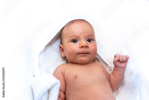 Adorable 2 months old little baby boy on towel after bath over white background
