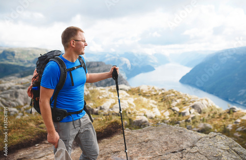 man with backpack and trekking stick at lysefjord