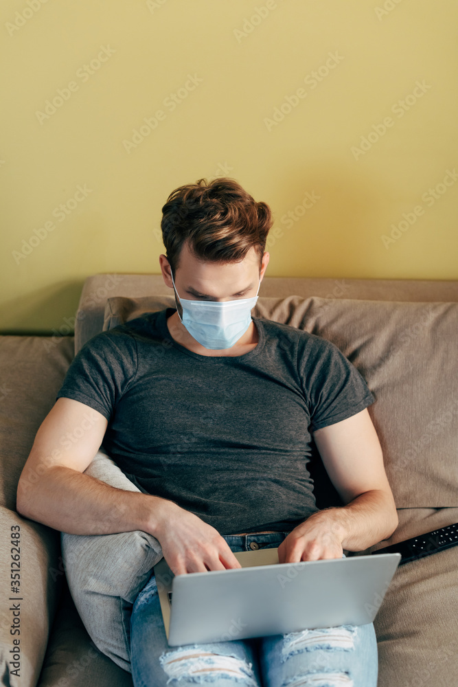 freelancer in medical mask using laptop at home freelancer in medical mask using laptop at home