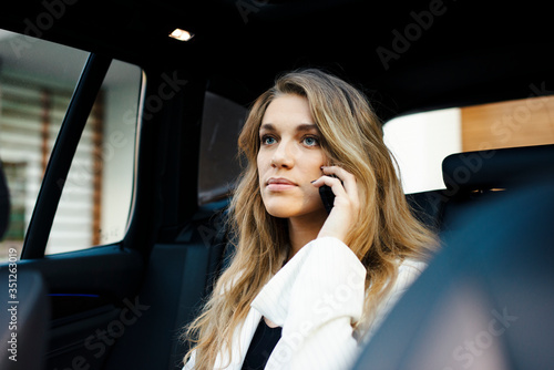 Business woman is using car transportation while working on phone © seligaa