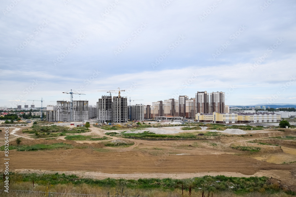 construction of multi-storey residential buildings. Tower cranes at a construction site.