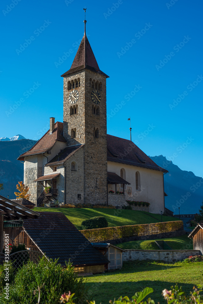 Old Swiss church with a blue sky and mountains 
