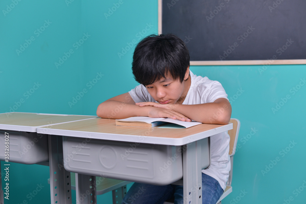 Asian student reading book in classroom Asian student reading book in classroom