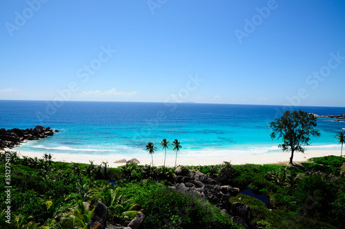 Idyllic beach with granitic rocks and palms in Anse Cocos, La Digue island, Seychelles