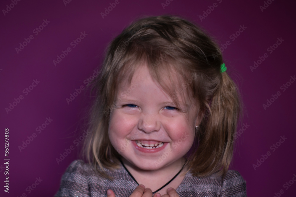 portrait of happy a three year old blond girl with blue eyes on a pink background portrait of happy a three year old blond girl with blue eyes on a pink background