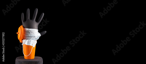 Inflated black glove and medical mask in a trash can on a black background. Banner. Copy space. Concept-save nature from a new type of garbage resulting from the outbreak of the coronavirus pandemic photo