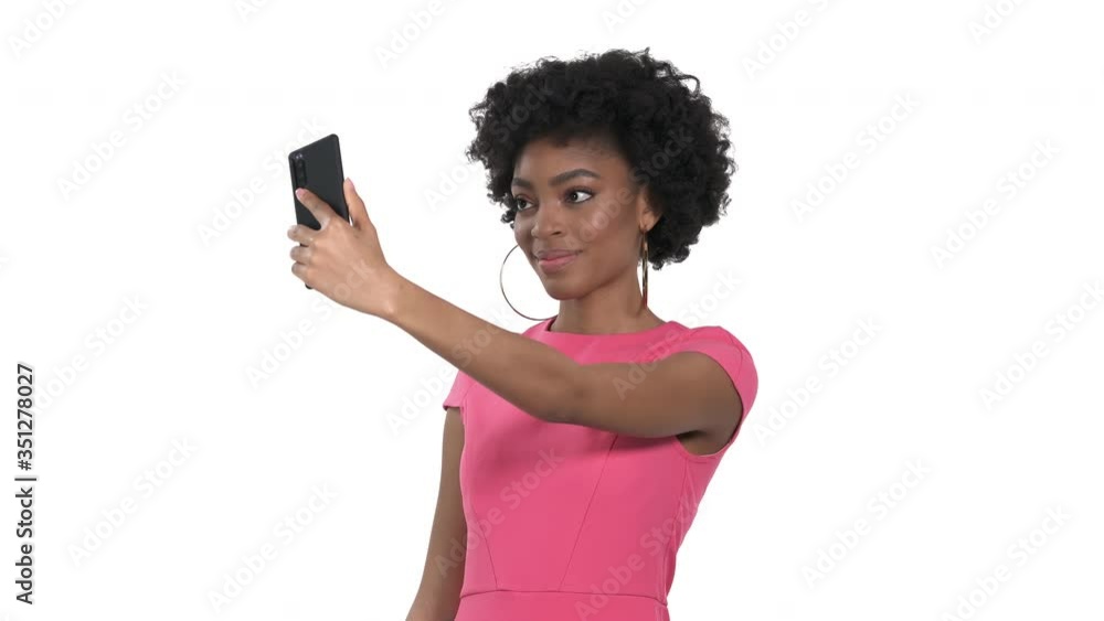 Close-up portrait of a charming African woman with afro hairstyle making selfie. Isolated, on white background Close-up portrait of a charming African woman with afro hairstyle making selfie. Isolated, on white background