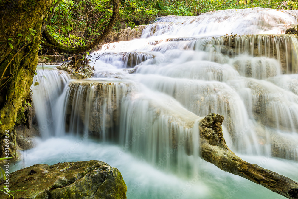 Obraz premium Waterfall and blue emerald water color in Erawan national park. Erawan Waterfall tier, Beautiful nature rock waterfall steps in tropical rainforest at Kanchanaburi province, Thailand