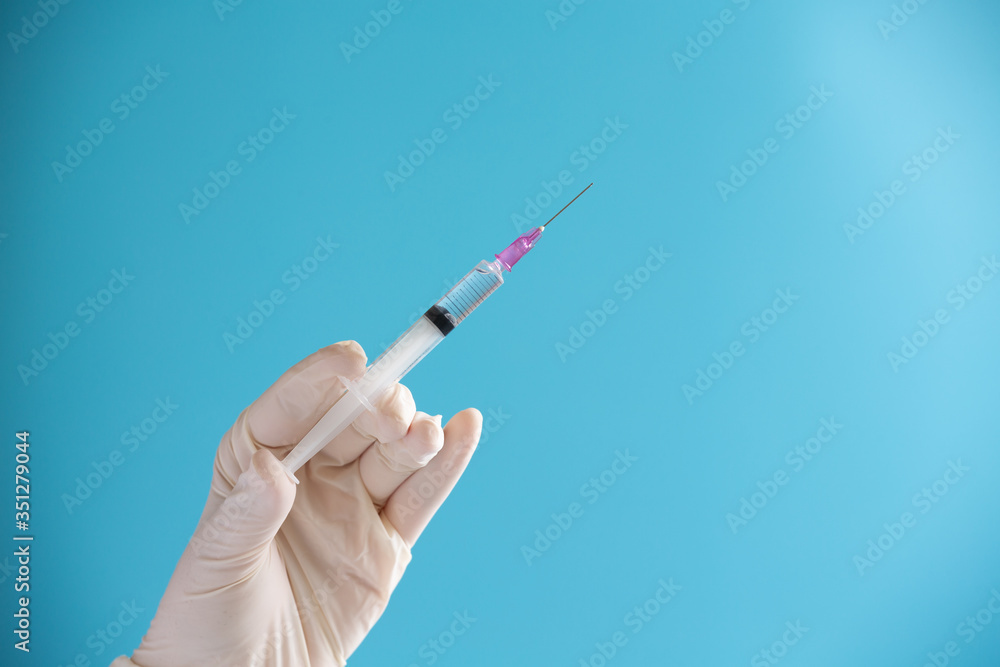 Doctor hand hold Syringe vaccine for corona virus on isolate blue background concept Coronavirus pandemic disease, COVID-19 virus from epidemic outbreak to wide concept for social scientist vaccine Doctor hand hold Syringe vaccine for corona virus on isolate blue background concept Coronavirus pandemic disease, COVID-19 virus from epidemic outbreak to wide concept for social scientist vaccine