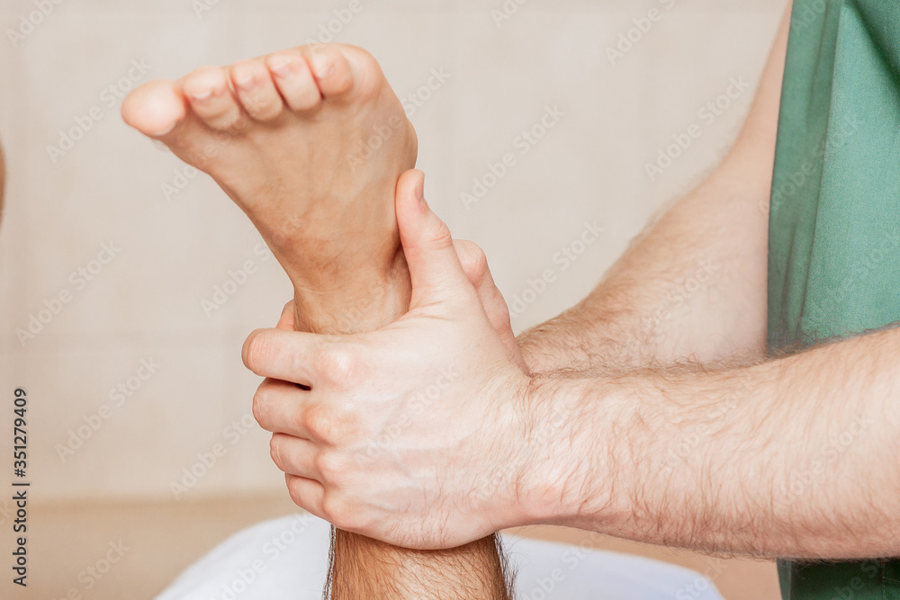 Fototapeta premium Close up of foot of man in hand of massage therapist during health procedure.