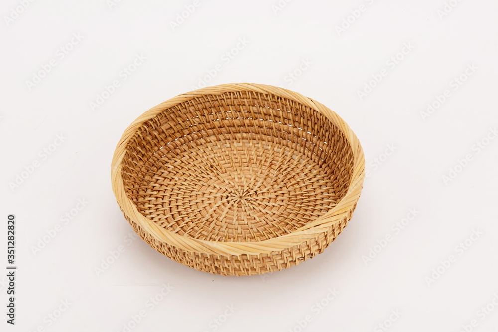 A woven bamboo basket isolated against a white background A woven bamboo basket isolated against a white background