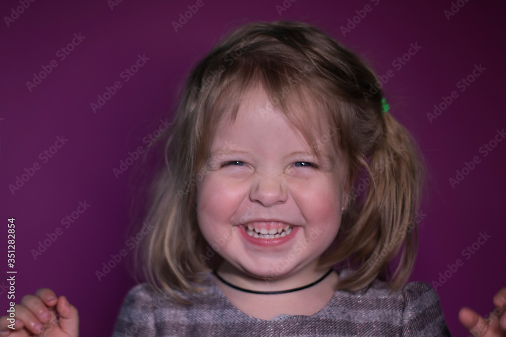 portrait of happy a three year old blond girl with blue eyes on a pink background portrait of happy a three year old blond girl with blue eyes on a pink background