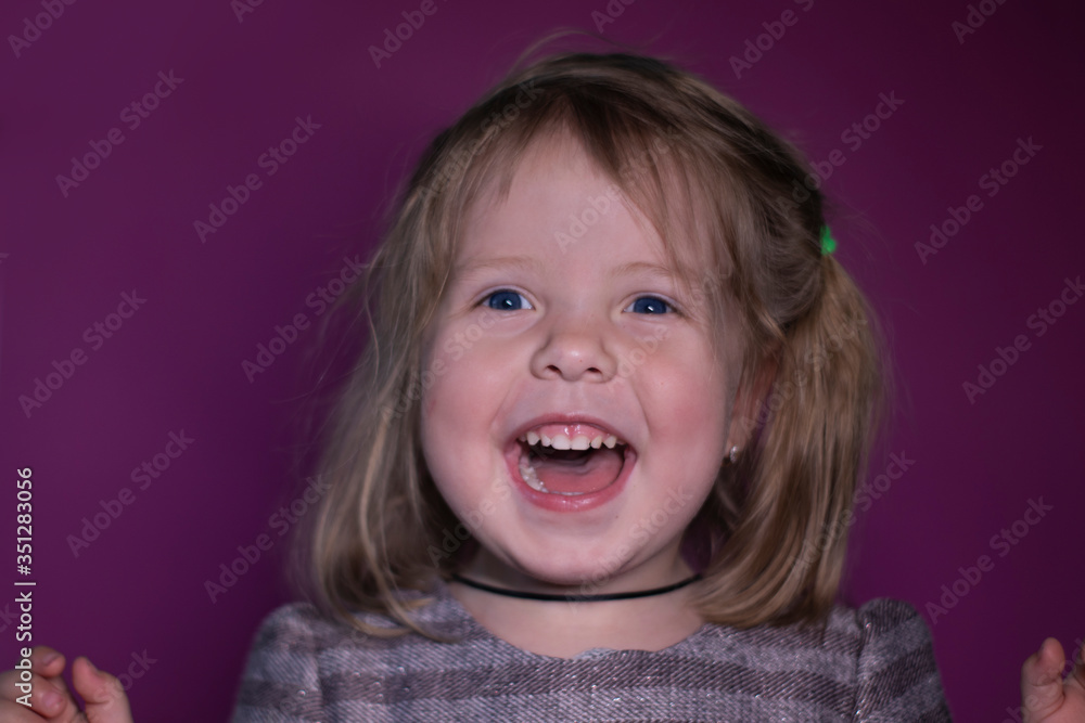 portrait of happy a three year old blond girl with blue eyes on a pink background portrait of happy a three year old blond girl with blue eyes on a pink background