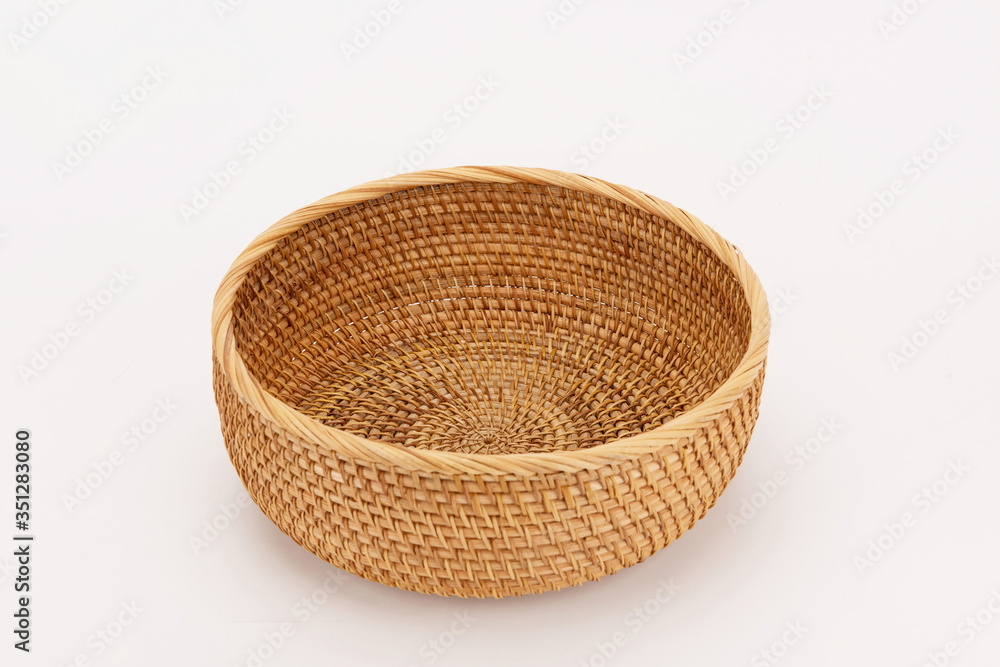 A woven bamboo basket isolated against a white background A woven bamboo basket isolated against a white background