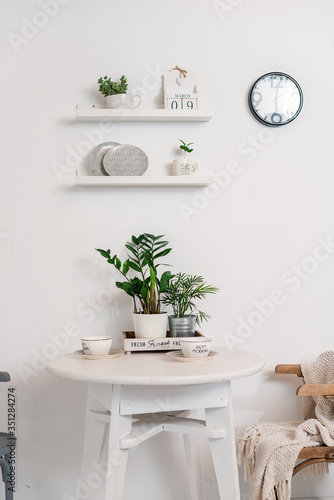 white dining table on a white wall © Oksana Smyshliaeva