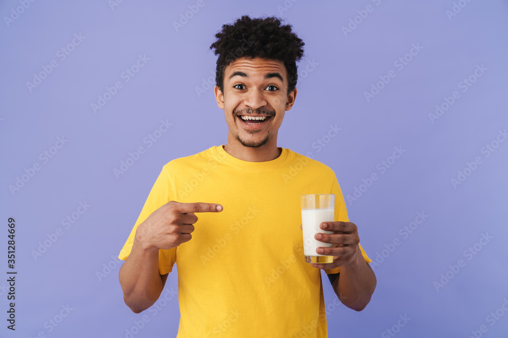 Photo of african american man pointing finger at glass with milk Photo of african american man pointing finger at glass with milk