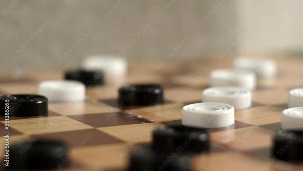 man's hand moves a black piece of checkers. man playing checkers close up. development strategy thinking man's hand moves a black piece of checkers. man playing checkers close up. development strategy thinking
