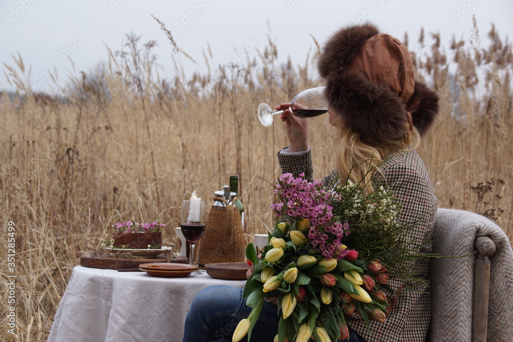 Fototapeta premium Kobieta na łące pijąca wino
