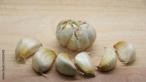 Unfocused  Blurry selective focus image  Garlic cloves on rustic in wooden table. Fresh peeled garlics and bulbs.