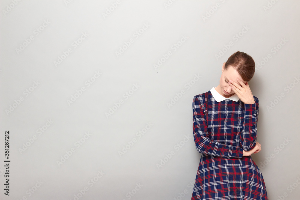 Portrait of girl touching forehead with hand and tilting head down Portrait of girl touching forehead with hand and tilting head down