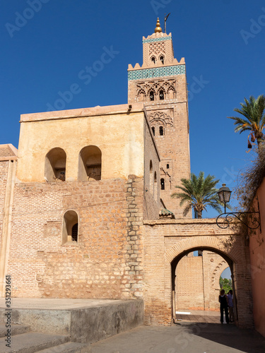 Minaret and part of the wall building of the Koutoubia Mosque decorated with archway in Marrakesh, Morocco. Traditional moroccan architecture