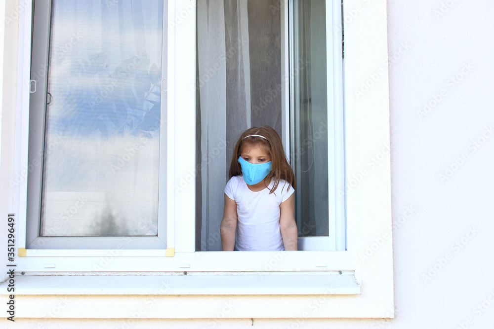 Little girl looks out the open window on isolation. Little girl looks out the open window on isolation.