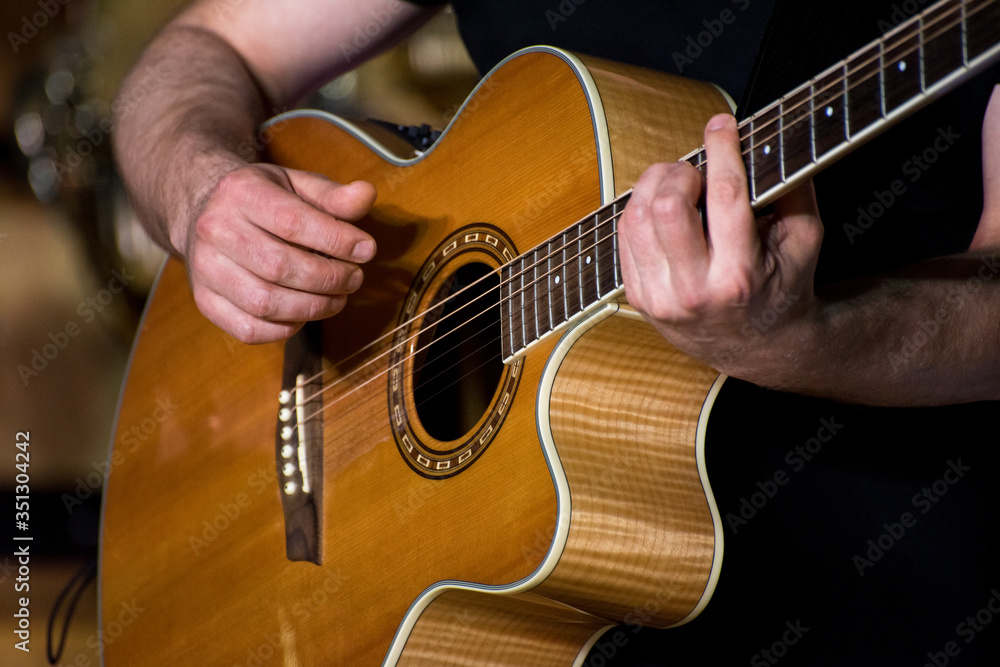 Fototapeta premium Close up of man's hands playing acoustic guitar