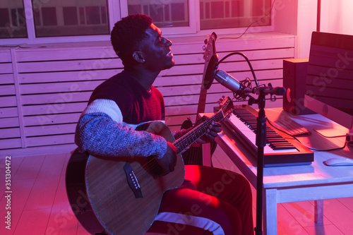 Canvas Print African american professional musician recording guitar in digital studio at home, music production technology concept