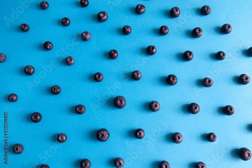 Pattern of natural raw yummy blueberries on a blue background