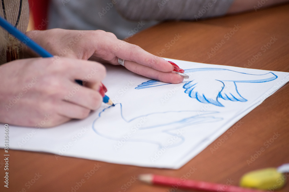 Drawing lesson, close-up girls hands draw on paper Drawing lesson, close-up girls hands draw on paper