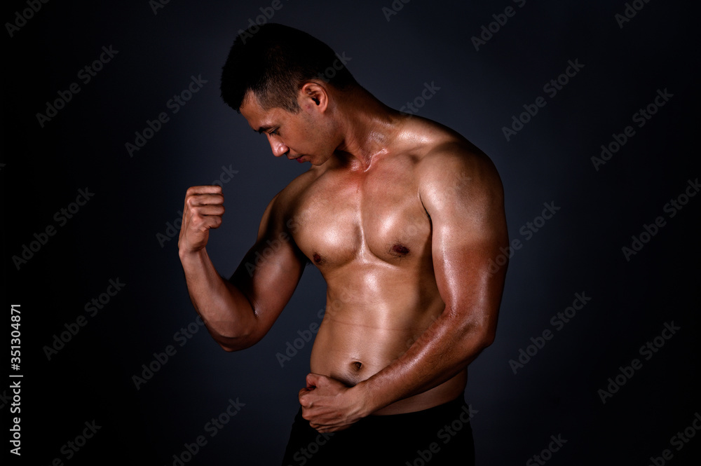 A strong Asian man raised his arms to show his strong and beautiful muscles from exercise