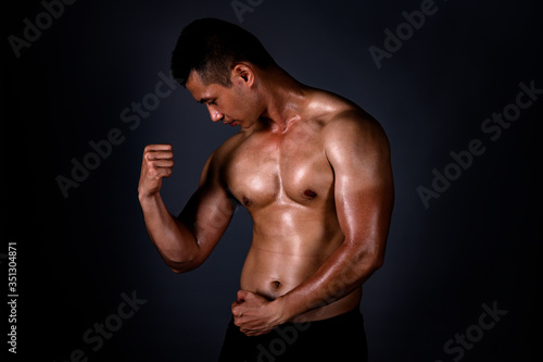 A strong Asian man raised his arms to show his strong and beautiful muscles from exercise