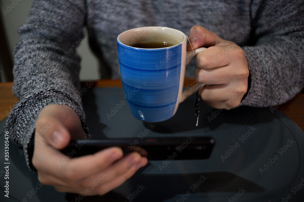 person holding a blue cup of tea person holding a blue cup of tea
