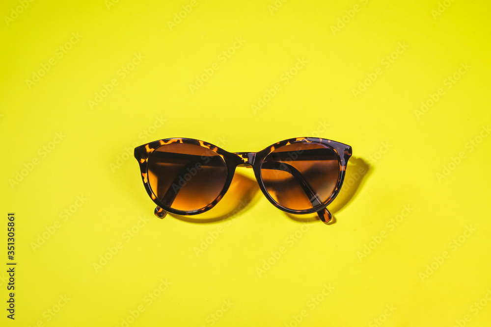 Sunglasses on a bright yellow background. Concept of weed summer, holiday and beach holidays. Minimalism, Flat lay Sunglasses on a bright yellow background. Concept of weed summer, holiday and beach holidays. Minimalism, Flat lay