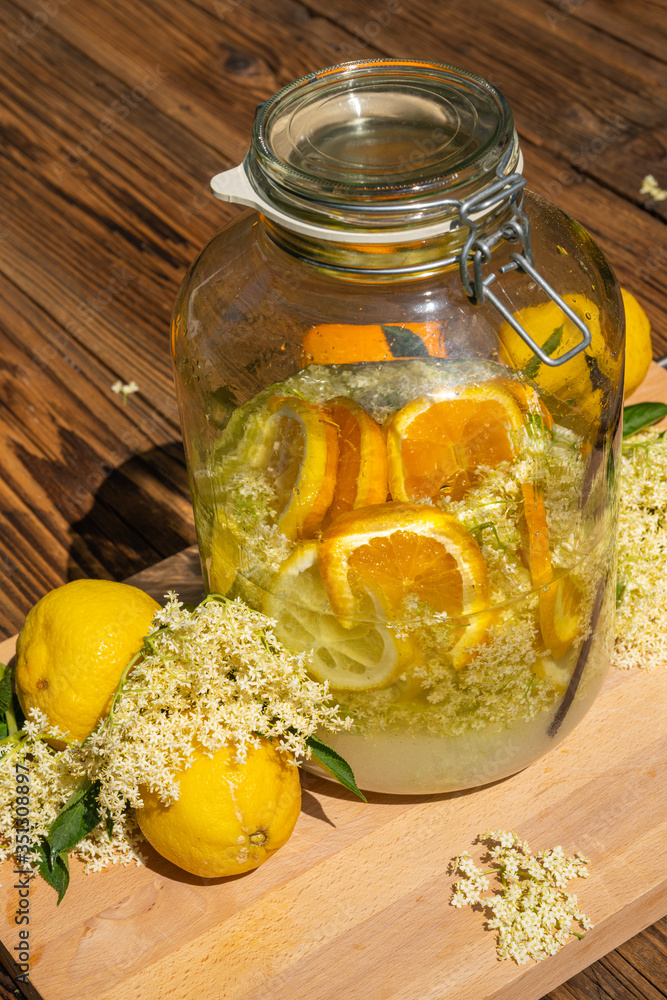 The elderflower liqueur is ready made, all ingredients are in the big preserving jar, fresh elderflowers, oranges and lemon slices, sugar, the vanilla pod and vodka The elderflower liqueur is ready made, all ingredients are in the big preserving jar, fresh elderflowers, oranges and lemon slices, sugar, the vanilla pod and vodka
