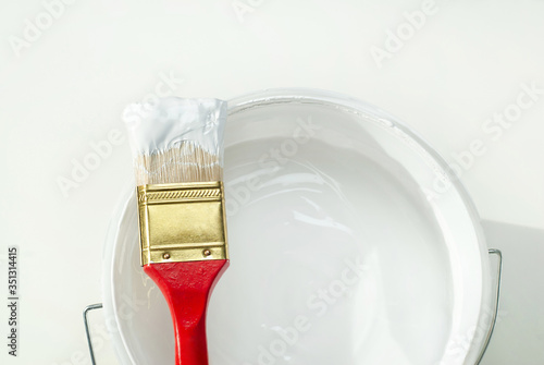 House repair, paintbrush with a bucket of white paint