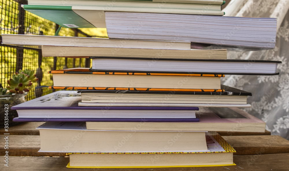 Fototapeta premium Stack of book of different sizes and color photographed from close up