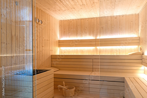 Empty interior of traditional Finnish sauna room. Modern wooden spa therapy cabin with hot dry steam photo