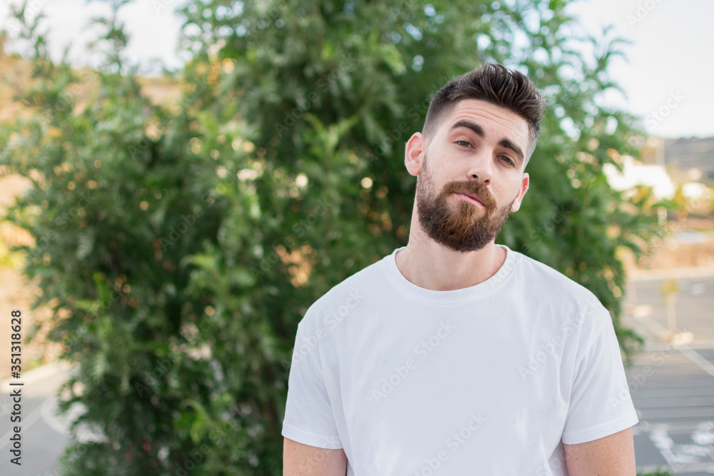Handsome man with a beard and white t-shirt outdoors. Handsome man with a beard and white t-shirt outdoors.