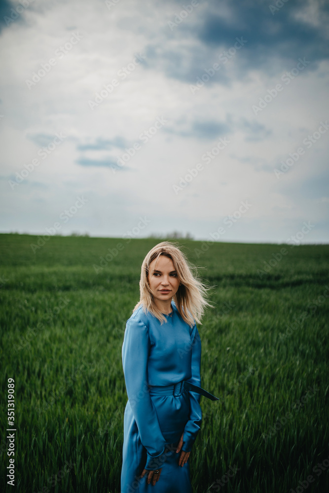 A young woman walks among the field of wheat. A young woman walks among the field of wheat.